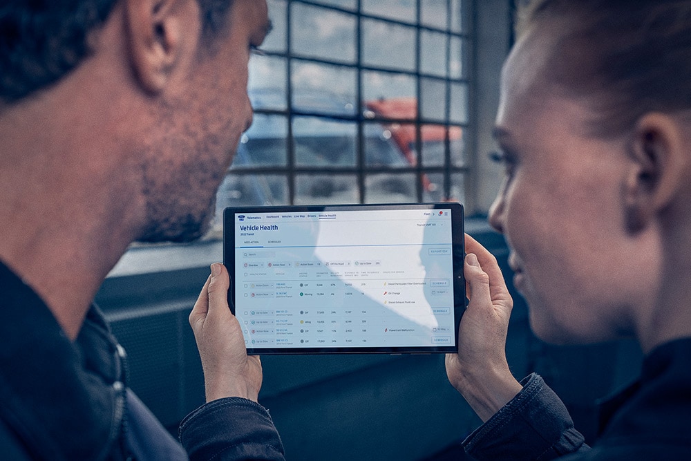 Ford Pro Eu Service 3X2 Fcsd Ford Pro Service 2022 E Transit Smart Maintenance Telematics Customer Fleet Manager Looking Onto Tablet 1000X667 Ccds